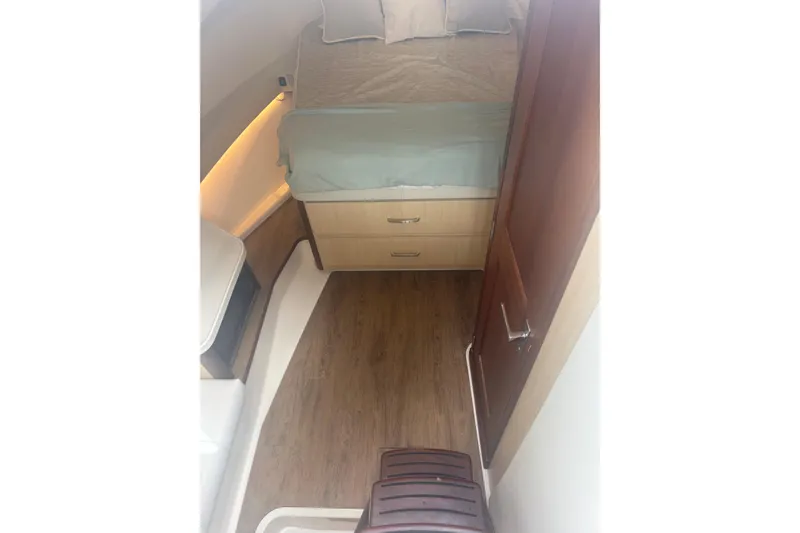 Slide: The Image of 2024 Regal 36 XO cabin interior with bed, wooden flooring, and storage drawers. - 27