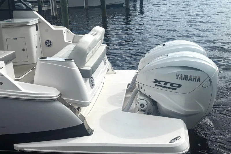 Slide: The Image of 2024 Regal 36 XO boat with Yamaha XTO Offshore engines docked on water. - 6