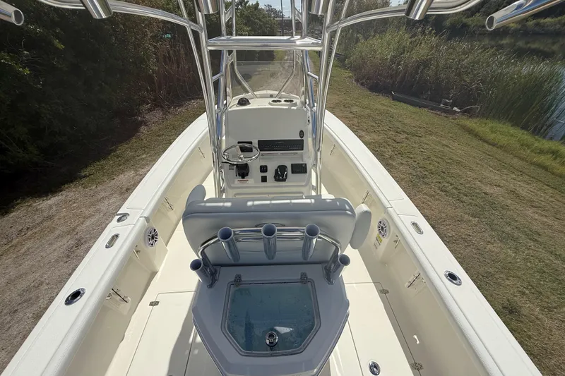Slide: The Image of 2026 Pathfinder 2400 Open boat interior with console and seating, docked near grassy area. - 14