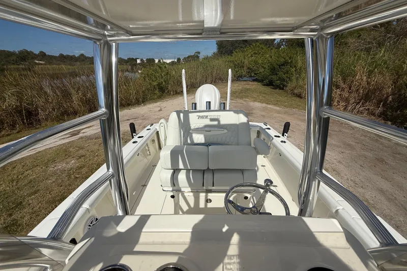 Slide: The Image of 2026 Pathfinder 2400 Open boat interior with seating and steering wheel, surrounded by nature. - 25