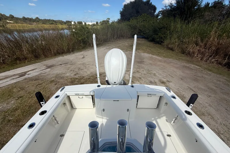 Slide: The Image of 2026 Pathfinder 2400 Open boat at a lakeside launch area, surrounded by reeds. - 27