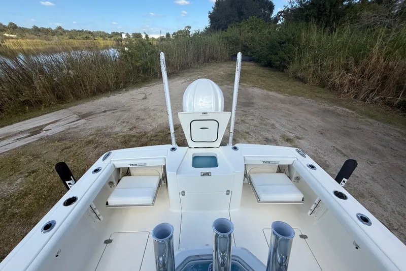 Slide: The Image of 2026 Pathfinder 2400 Open boat interior with seating and storage, near a scenic lakeside. - 28