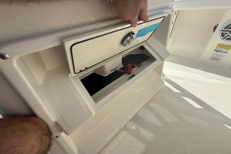Slide: The Image of Storage compartment on a 2026 Pathfinder 2400 Open boat, featuring secure latch and interior space. - 42
