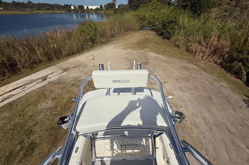Slide: The Image of 2026 Pathfinder 2400 Open boat near a serene lake with lush greenery. - 53