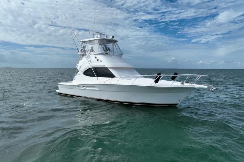 Slide: The Image of 2005 Riviera 40 Flybridge yacht on open sea under cloudy sky. - 0