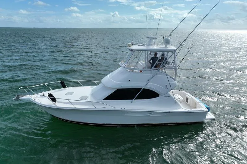Slide: The Image of 2005 Riviera 40 Flybridge yacht cruising on open water under a clear sky. - 1