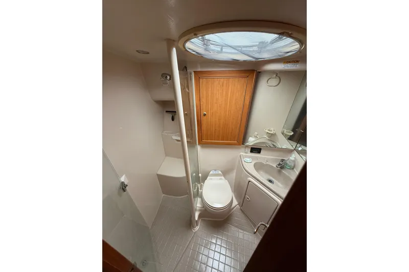 Slide: The Image of 2005 Riviera 40 Flybridge yacht bathroom with toilet, sink, and shower. - 10
