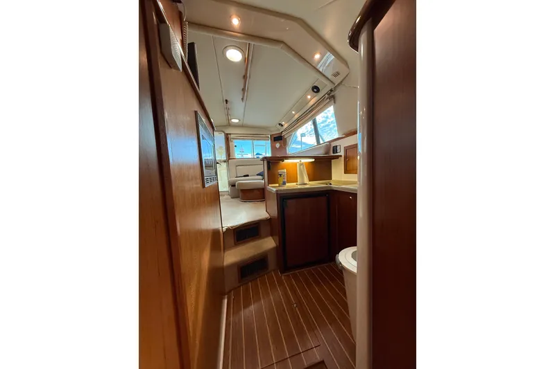 Slide: The Image of Interior of 2005 Riviera 40 Flybridge yacht, featuring wood finishes and compact kitchen area. - 12
