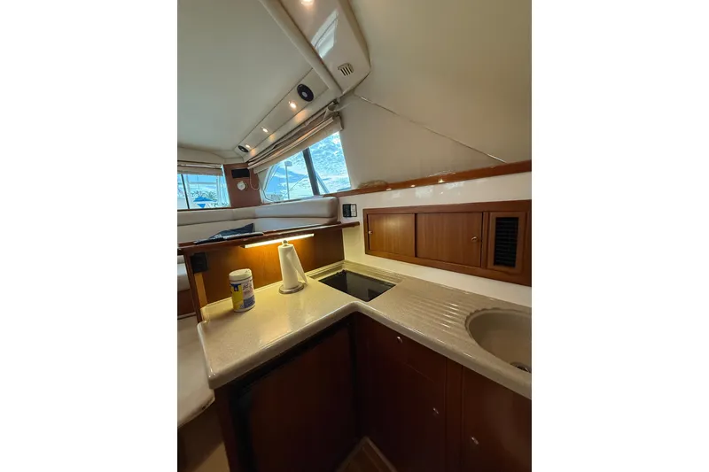 Slide: The Image of 2005 Riviera 40 Flybridge yacht interior kitchen with wooden cabinets and countertop. - 13