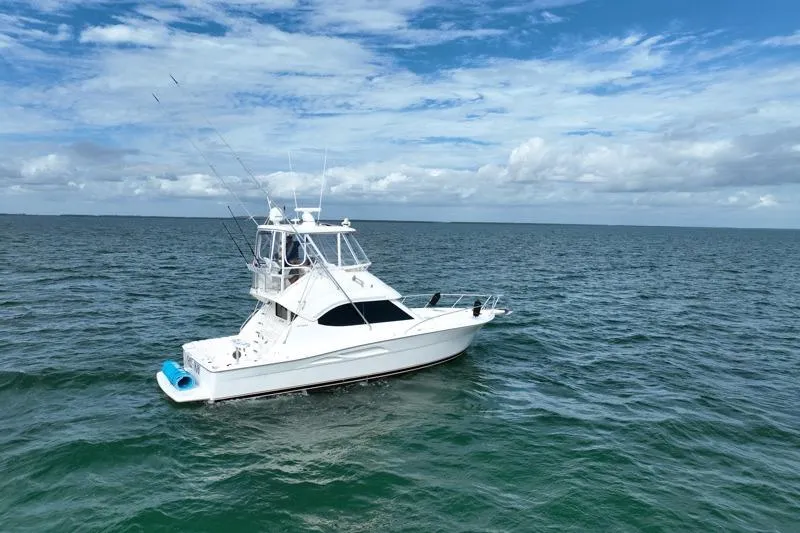 Slide: The Image of 2005 Riviera 40 Flybridge yacht cruising on open sea under blue sky. - 2