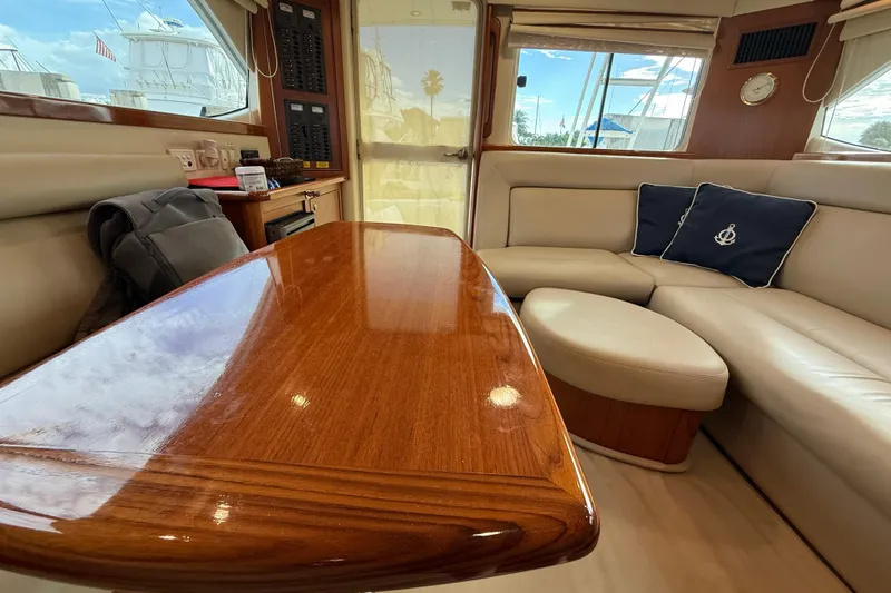 Slide: The Image of Luxurious interior of 2005 Riviera 40 Flybridge yacht with polished wood table and plush seating. - 20