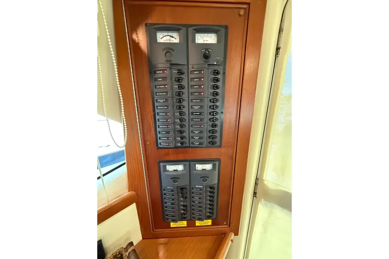 Slide: The Image of Electrical panel on 2005 Riviera 40 Flybridge yacht, featuring multiple switches and meters. - 22