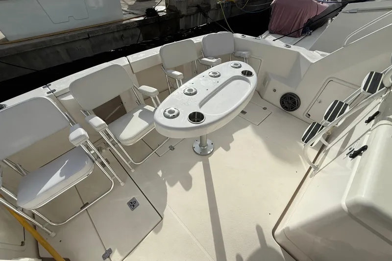 Slide: The Image of 2005 Riviera 40 Flybridge yacht deck with seating and table setup. - 23