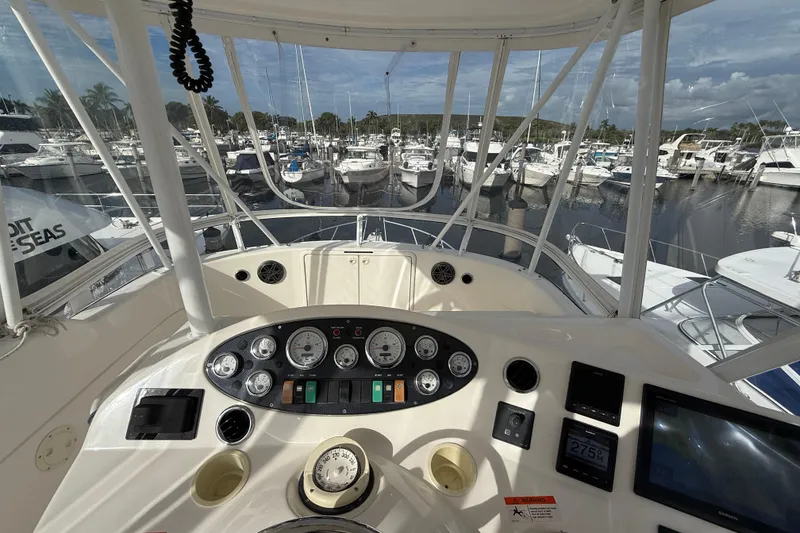 Slide: The Image of Cockpit view of 2005 Riviera 40 Flybridge yacht at marina, showcasing control panel and gauges. - 29
