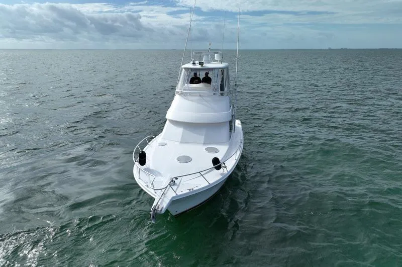 Slide: The Image of 2005 Riviera 40 Flybridge yacht cruising on open sea under cloudy sky. - 3