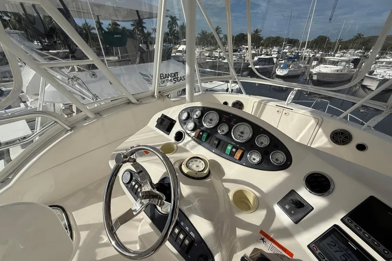 Slide: The Image of Helm of 2005 Riviera 40 Flybridge yacht with gauges and steering wheel, docked at marina. - 31