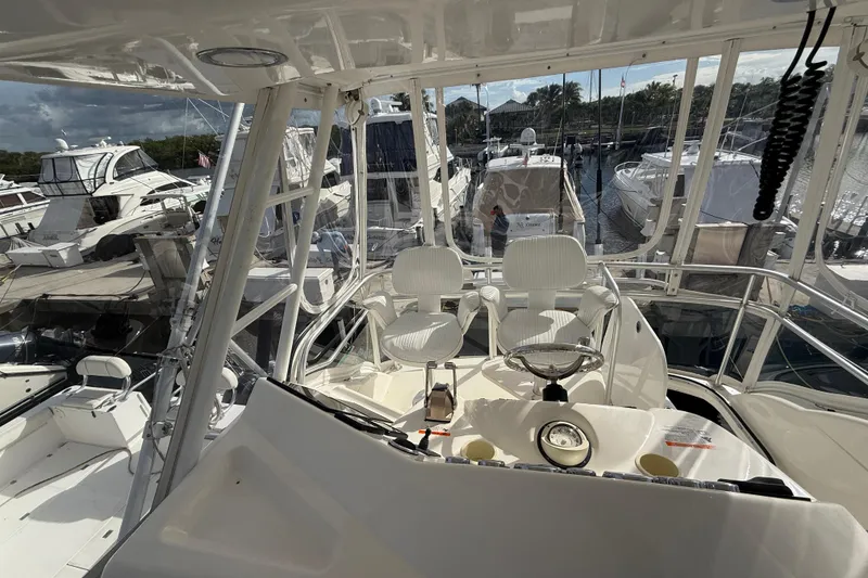 Slide: The Image of 2005 Riviera 40 Flybridge yacht interior with helm, docked among other boats. - 36