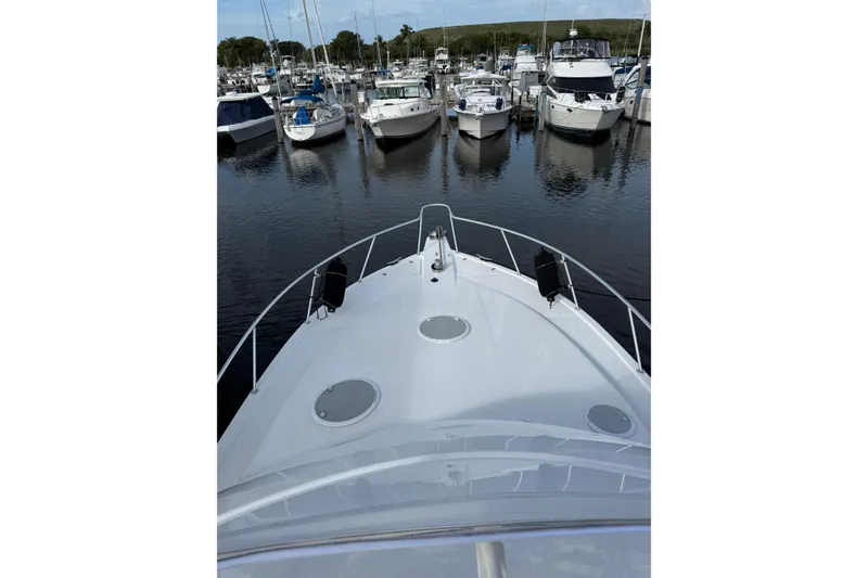 Slide: The Image of Bow view of 2005 Riviera 40 Flybridge yacht docked in a marina. - 37