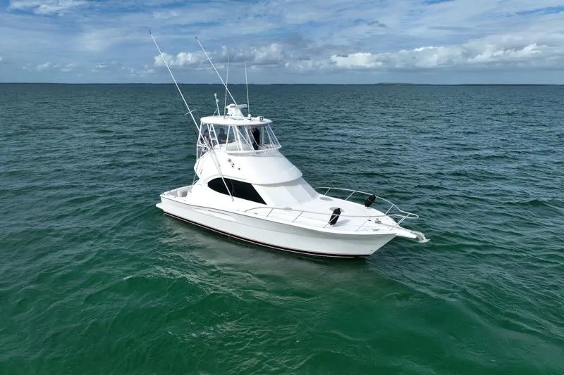 Slide: The Image of 2005 Riviera 40 Flybridge yacht cruising on open sea under blue sky. - 5