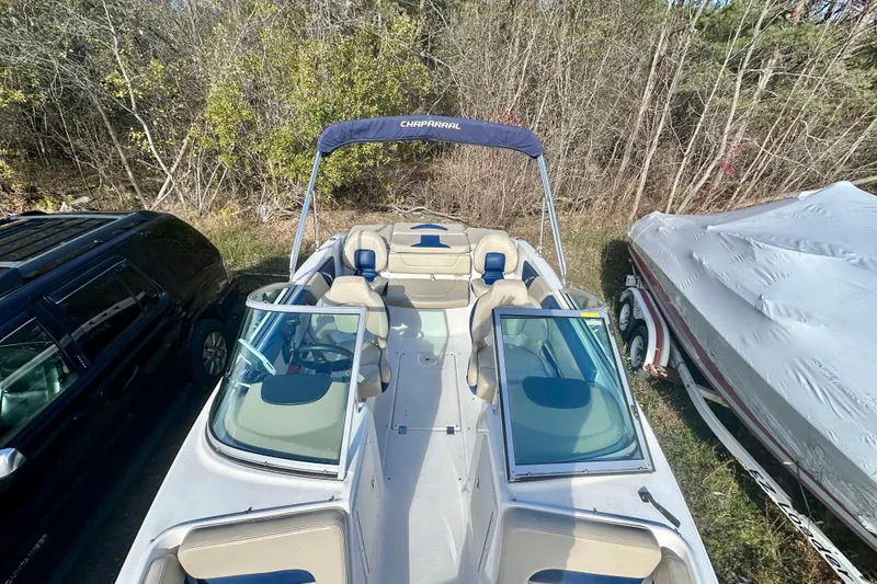 Slide: The Image of 2018 Chaparral 19 H2O Ski & Fish boat with open bow seating, parked outdoors. - 13