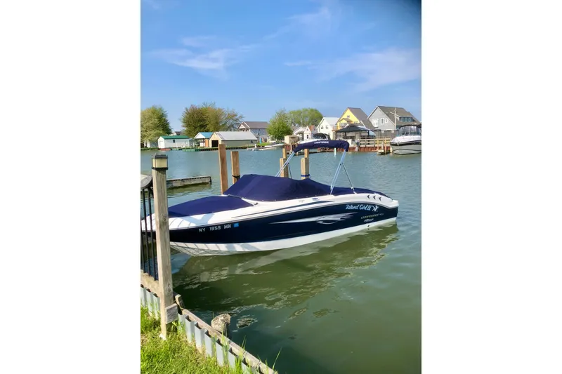 Slide: The Image of 2018 Chaparral 19 H2O Ski & Fish boat docked in a scenic waterfront area. - 5