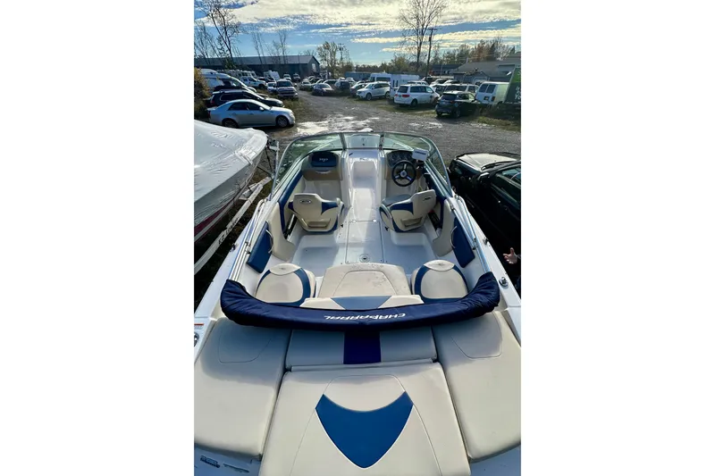 Slide: The Image of 2018 Chaparral 19 H2O Ski & Fish boat with blue and white interior, parked outdoors. - 6