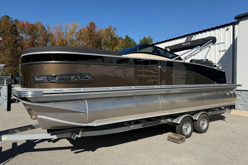 Slide: The Image of 2026 Tahoe Pontoon Cascade Quad Lounger Shift Windshield on trailer, outdoors. - 2