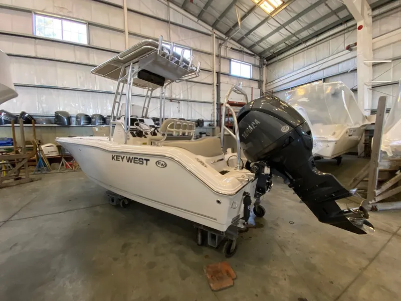 The Image of 2026 Key West 203 FS boat in a warehouse, featuring a Yamaha outboard motor. - 0