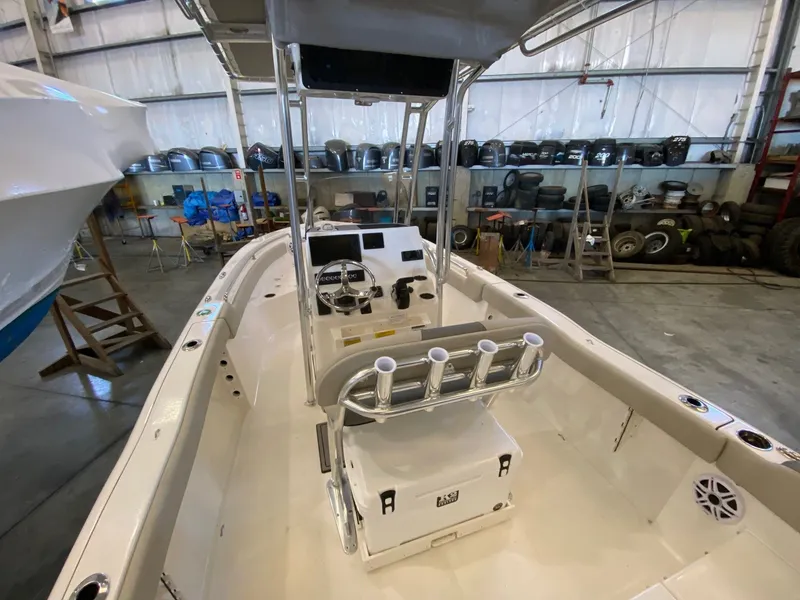 Slide: The Image of 2026 Key West 203 FS boat interior in a warehouse, showcasing steering console and rod holders. - 6