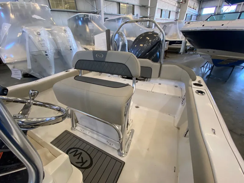 Slide: The Image of 2026 Key West 203 FS boat interior with seating and steering wheel in showroom. - 9