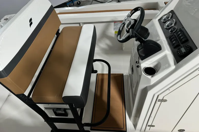 Slide: The Image of 2025 Starcraft SVX 211 OB CC boat interior with steering console and cushioned seating. - 14