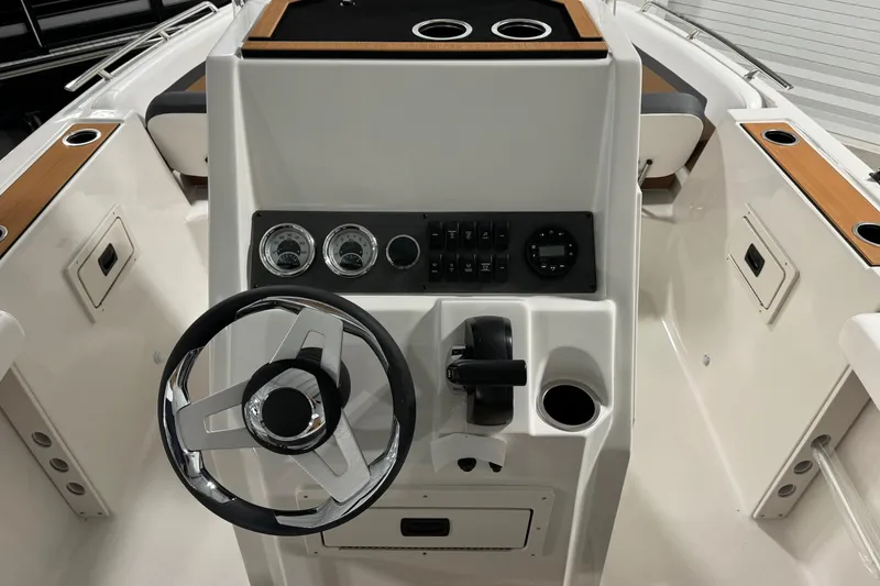 Slide: The Image of 2025 Starcraft SVX 211 OB CC boat console with steering wheel and control panel. - 15