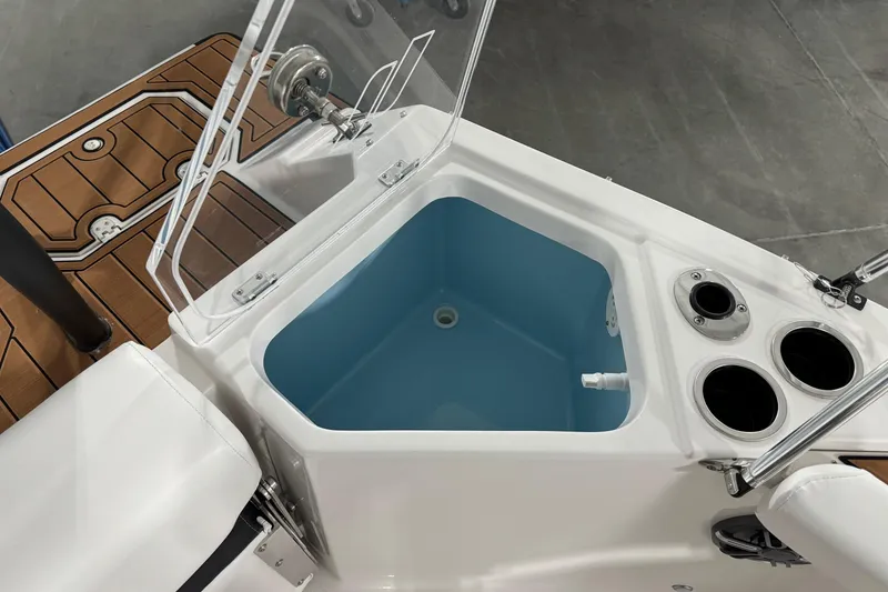 Slide: The Image of 2025 Starcraft SVX 211 OB CC boat interior with open storage compartment and cup holders. - 19