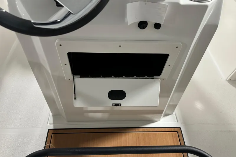 Slide: The Image of 2025 Starcraft SVX 211 OB CC boat console with storage compartment and steering wheel. - 20