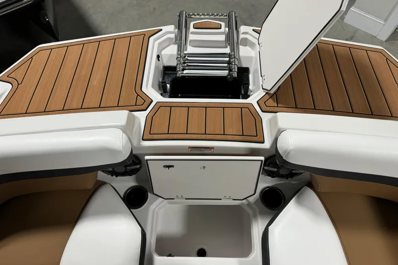 Slide: The Image of 2025 Starcraft SVX 211 OB CC boat interior with teak-style decking and storage compartments. - 7