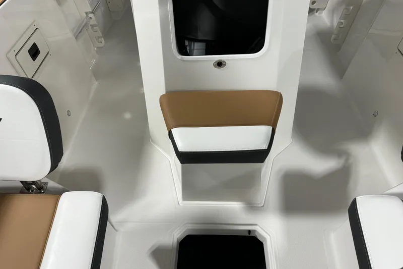 Slide: The Image of 2025 Starcraft SVX 211 OB CC boat interior with white and tan seating. - 10
