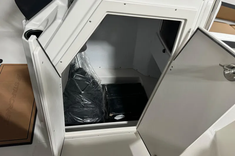 Slide: The Image of 2025 Starcraft SVX 211 OB CC boat storage compartment with open door, showcasing interior space. - 12