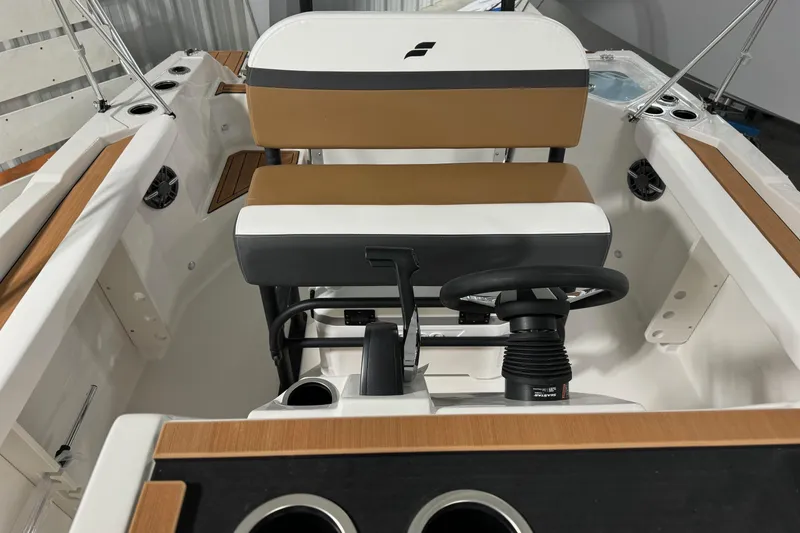 Slide: The Image of 2025 Starcraft SVX 211 OB CC boat interior with steering wheel and seating. - 13