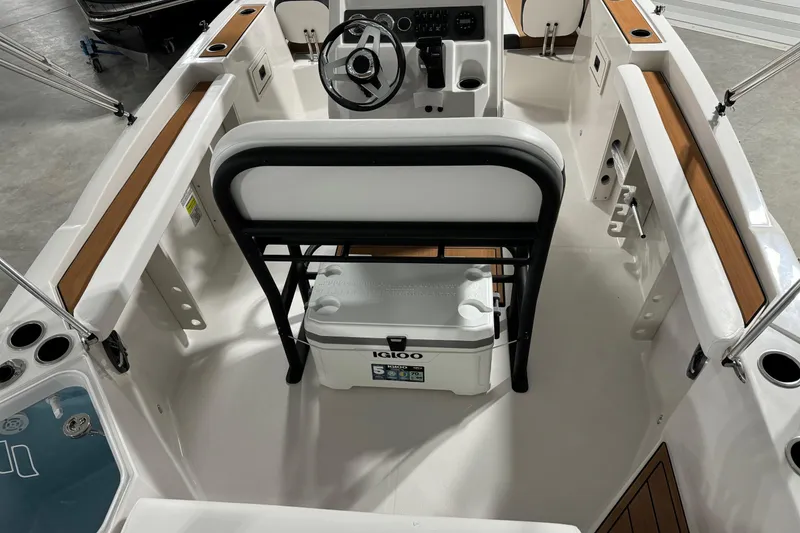 Slide: The Image of 2025 Starcraft SVX 211 OB CC boat interior with steering wheel and Igloo cooler. - 16