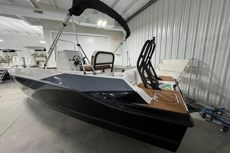 Slide: The Image of 2025 Starcraft SVX 211 OB CC boat in showroom, featuring sleek design and modern amenities. - 2