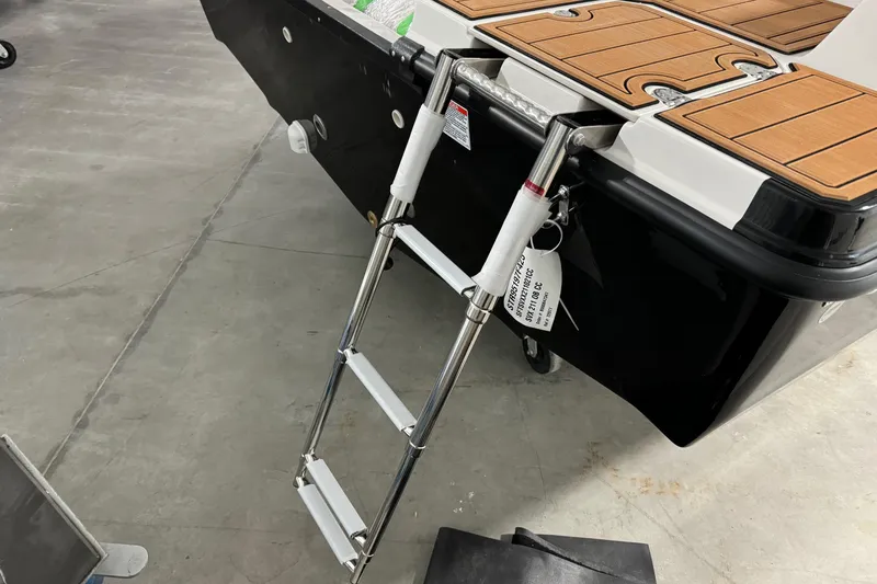Slide: The Image of 2025 Starcraft SVX 211 OB CC boat with foldable ladder on wooden deck. - 5