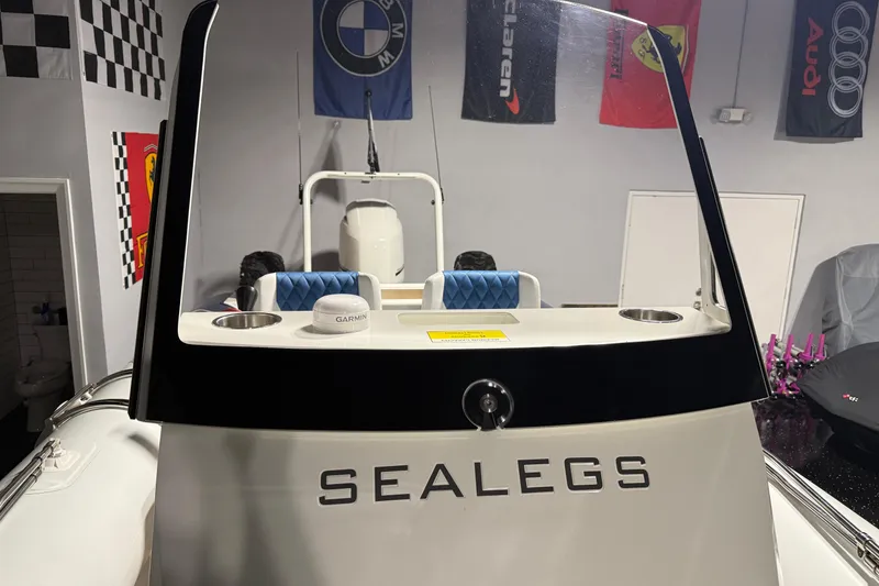 Slide: The Image of 2021 Sealegs 7.5M RIB boat in showroom with automotive banners. - 10