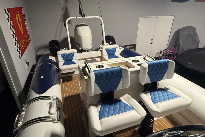 Slide: The Image of 2021 Sealegs 7.5M RIB with blue and white seating in a garage setting. - 21