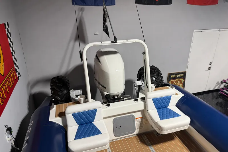 Slide: The Image of 2021 Sealegs 7.5M RIB with blue seating and outboard motor in a garage setting. - 27