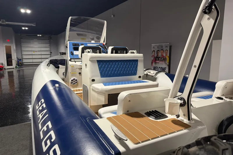Slide: The Image of 2021 Sealegs 7.5M RIB boat with blue seating, displayed indoors. - 30