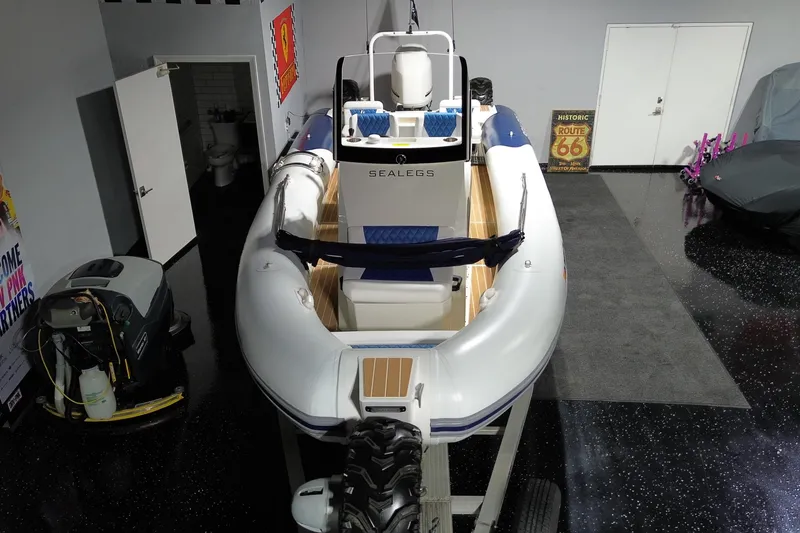 Slide: The Image of 2021 Sealegs 7.5M RIB boat in a garage, showcasing its sleek design. - 4