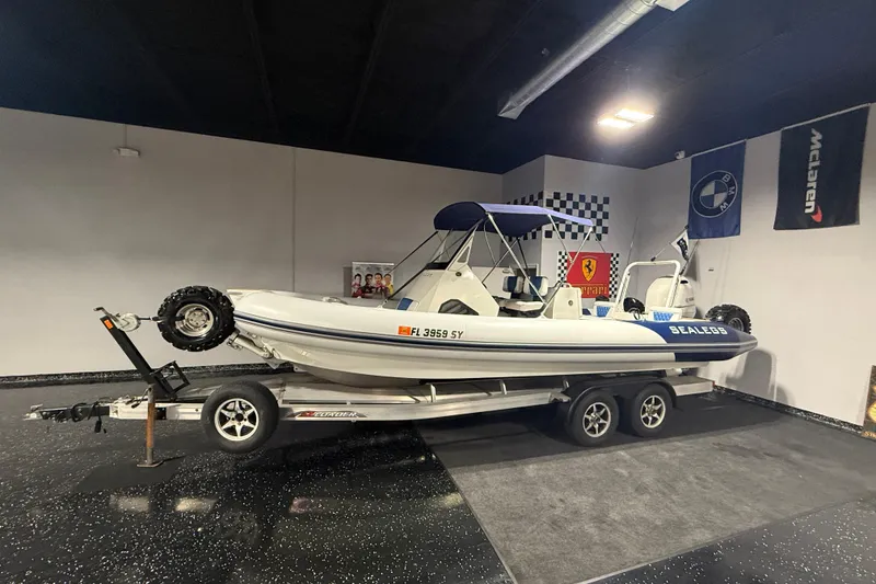 Slide: The Image of 2021 Sealegs 7.5M RIB on trailer in showroom with luxury car banners. - 46
