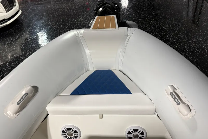 Slide: The Image of 2021 Sealegs 7.5M RIB interior with blue and white seating, speakers, and Sealegs branding. - 6