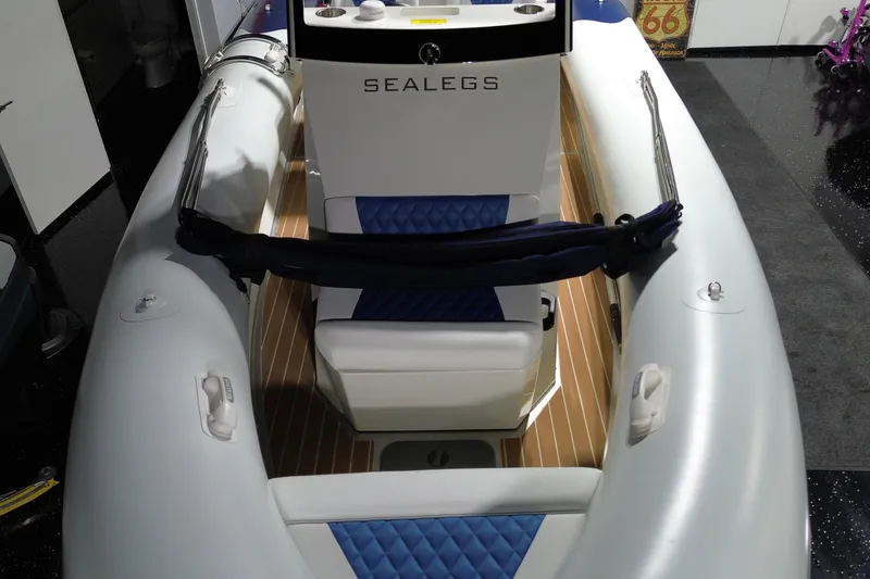 Slide: The Image of 2021 Sealegs 7.5M RIB boat interior with blue seating and wood accents. - 8
