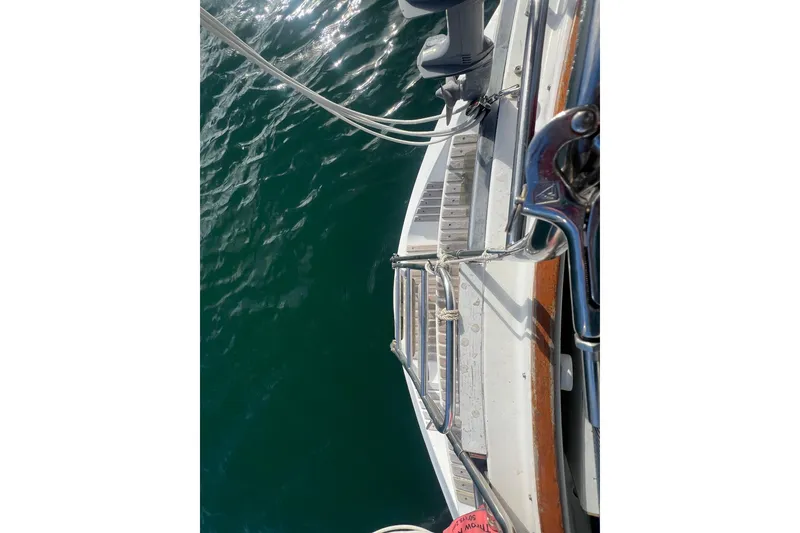 Slide: The Image of 1993 Compac Sloop sailboat deck with railing, overlooking calm green water. - 19